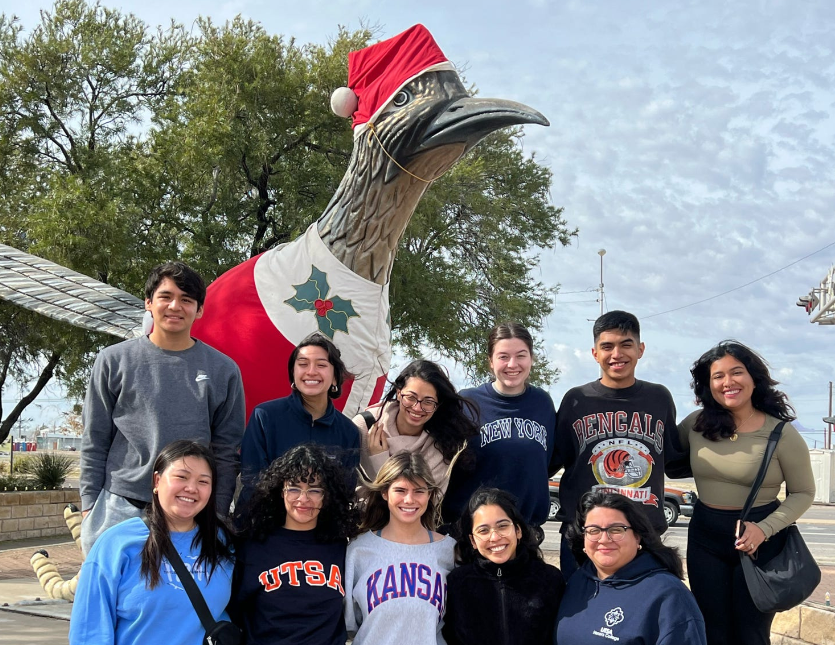 Group of UTSA students take a picture in front of a Roadrunner statue